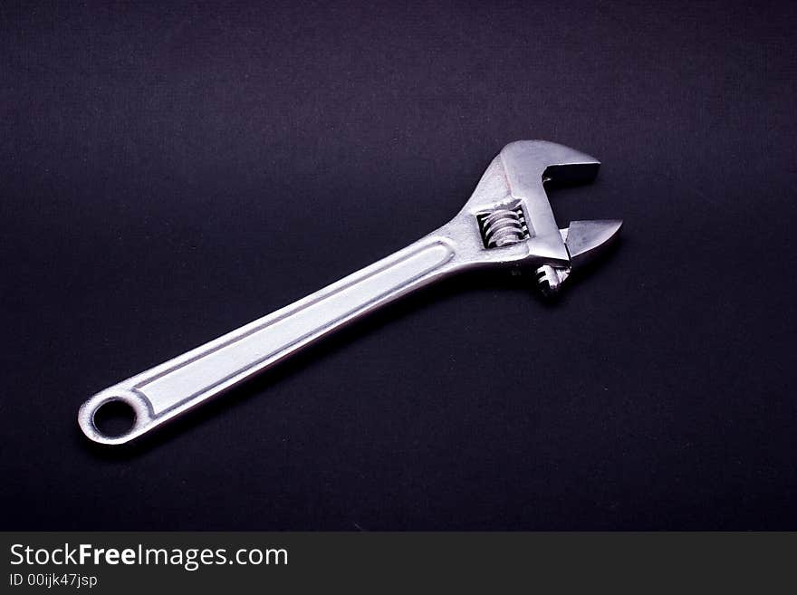 An adjustable spanner, isolated on black