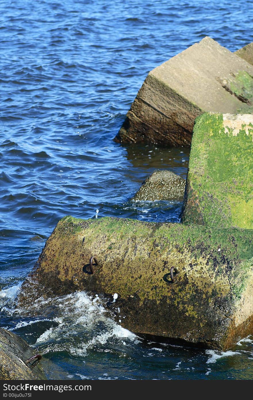 Concrete blocks of pier with waves