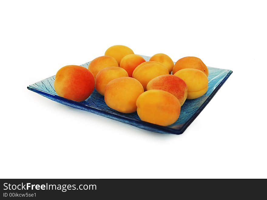 Sweet appricots on the blue glass plate