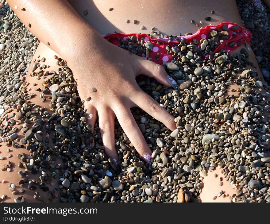 The sexual girl in a pebble on a beach