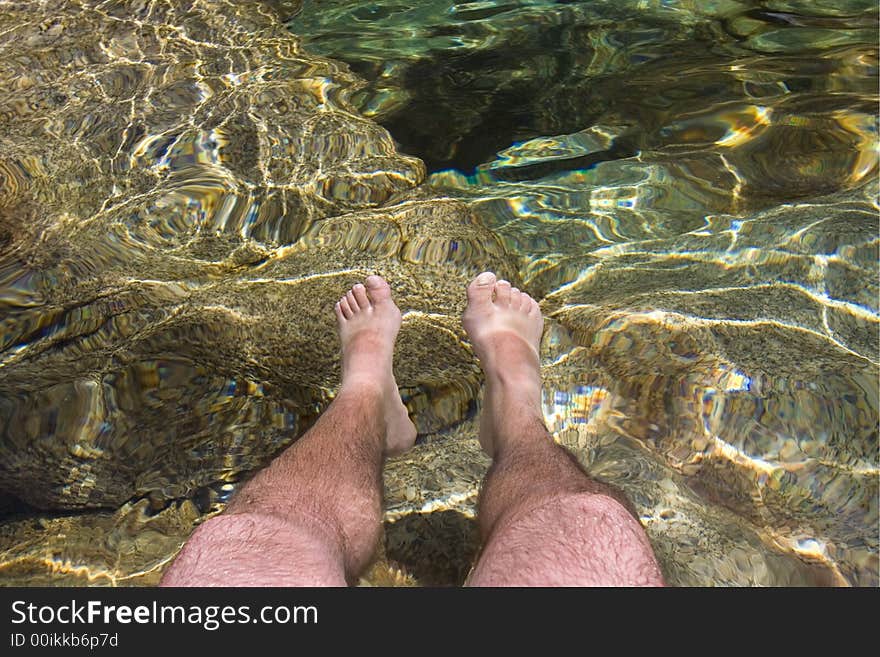 Men legs inside crystal clear water. Men legs inside crystal clear water