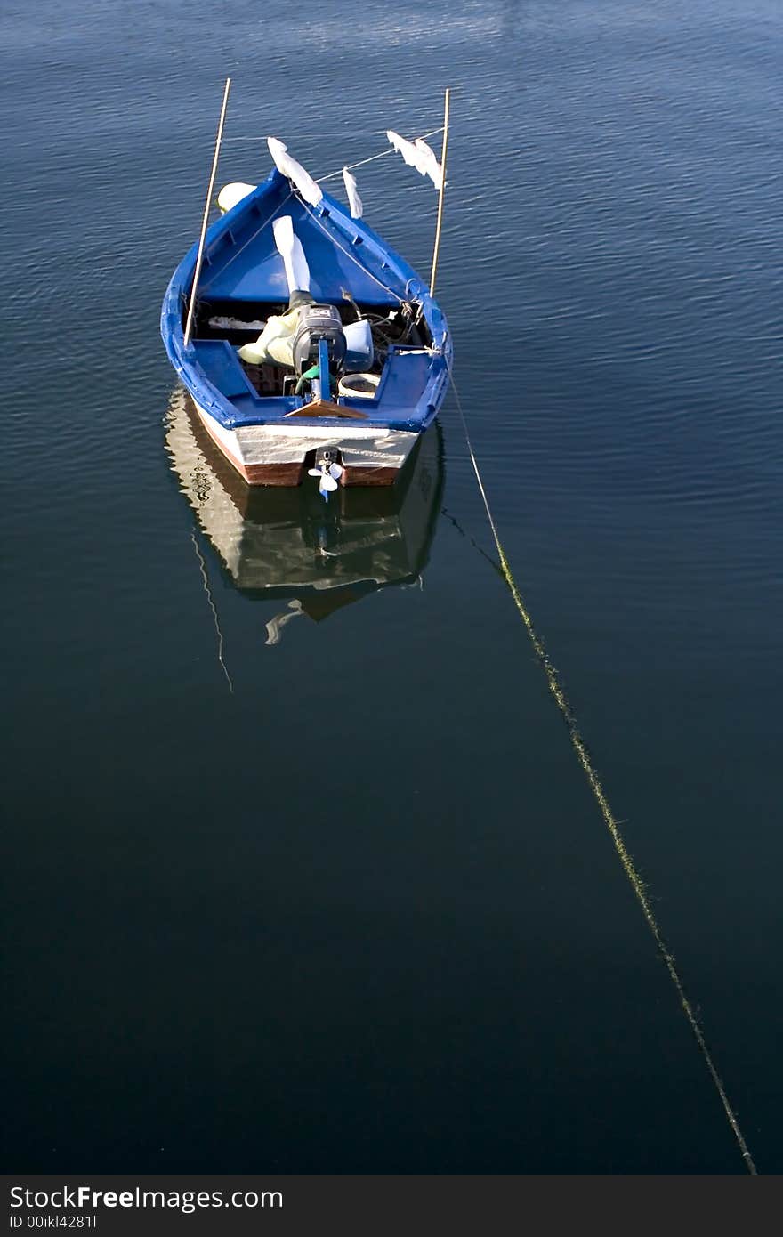 Small blue fishing boat alone in the ocean