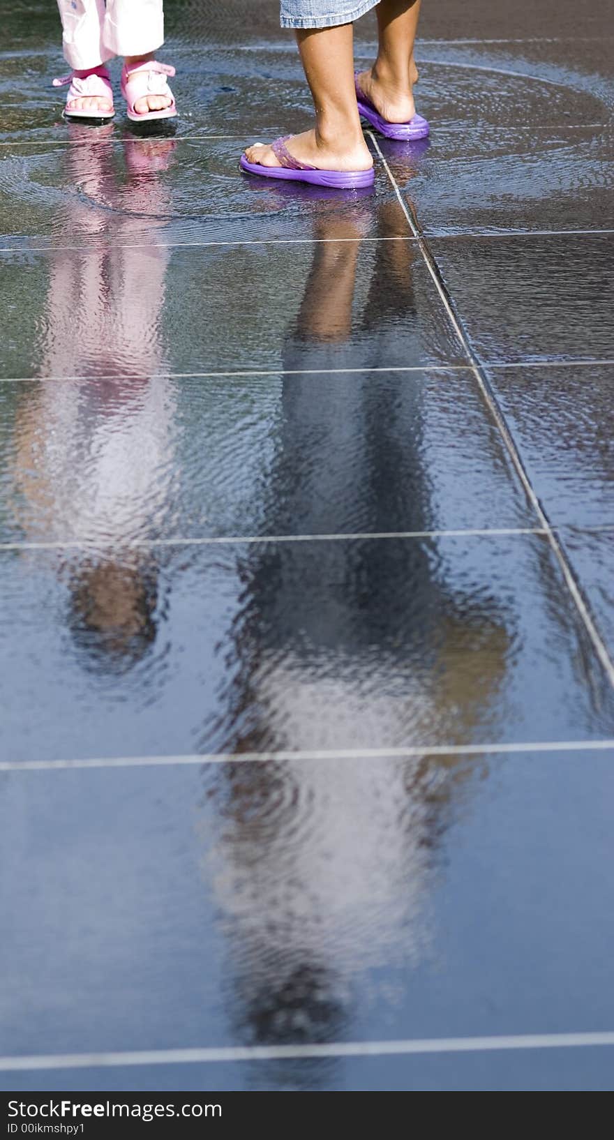 A young girl and her guardian standing on a pool of water. A young girl and her guardian standing on a pool of water