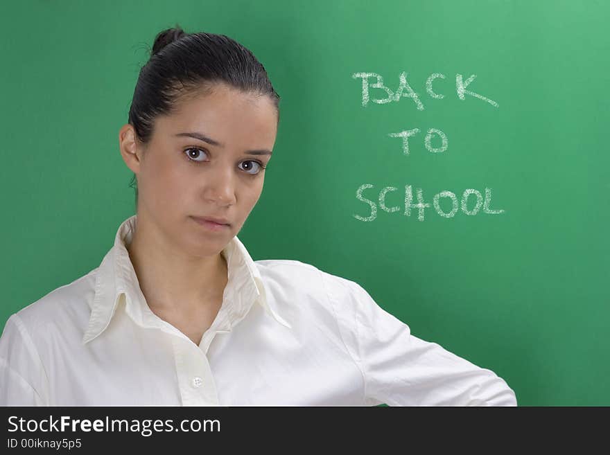 Young beautiful teacher in white on green background. Young beautiful teacher in white on green background