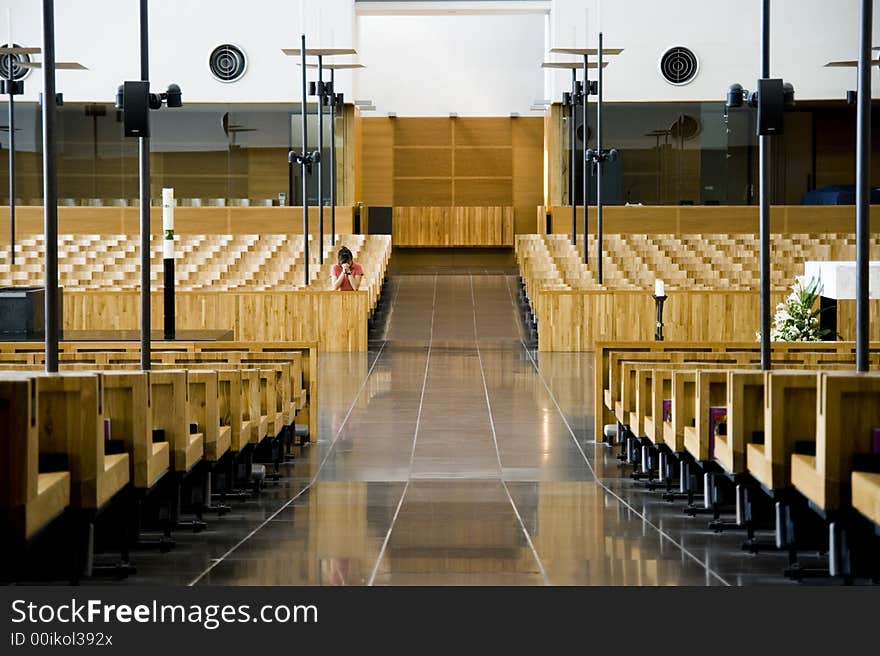 A woman prays in a church all by herself