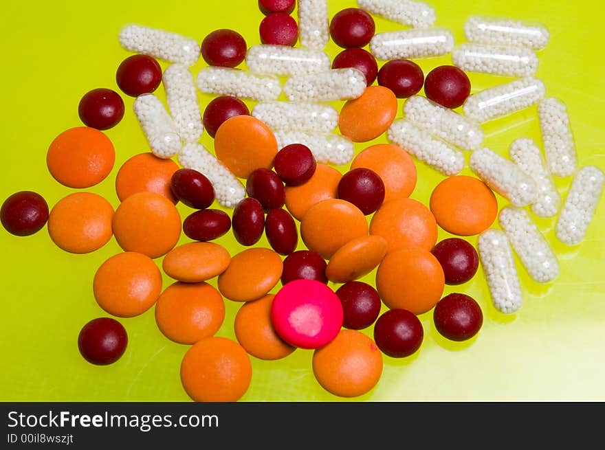 Some pills over a yellow table