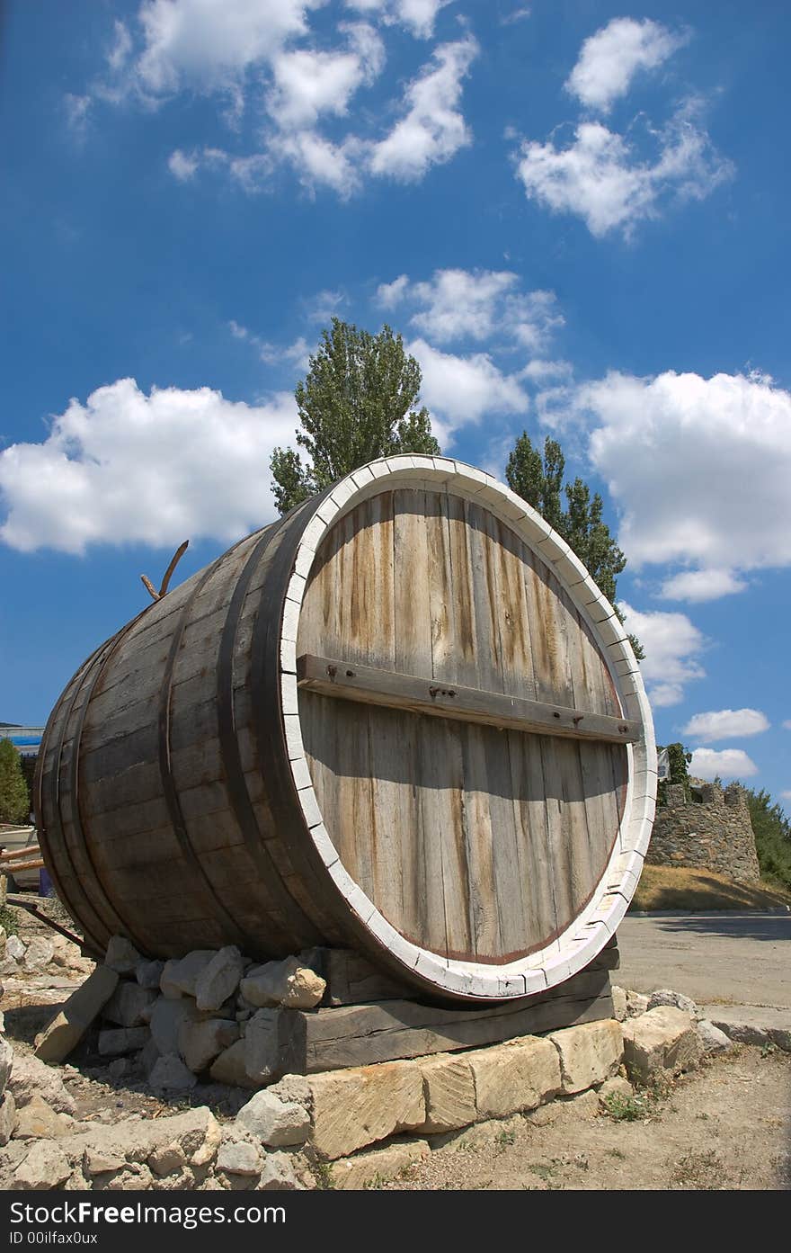 Big single wine barrel placed on bricks on sky background