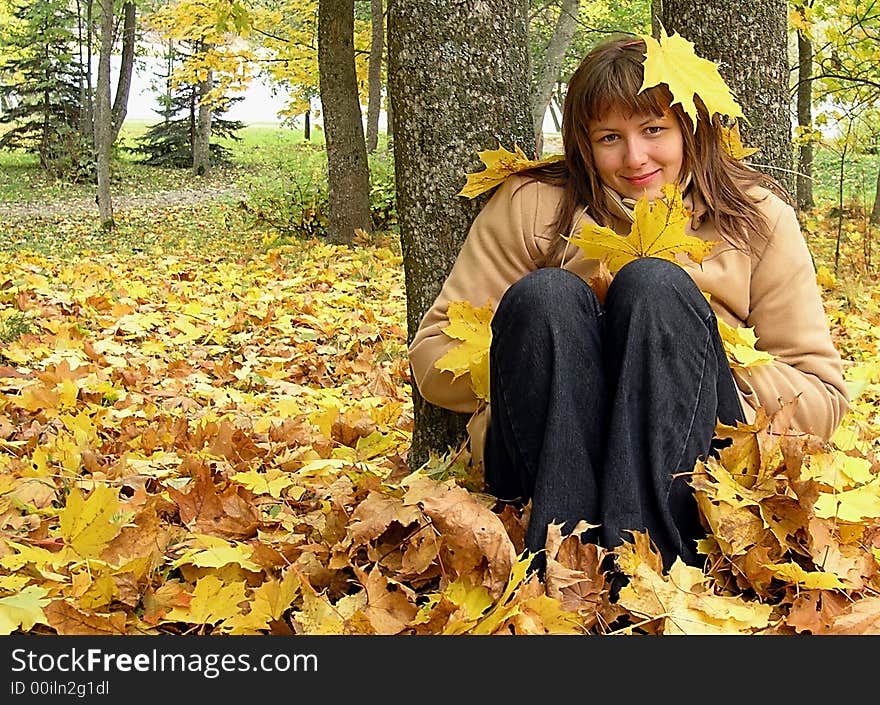 Nice young girl siting in the autumn forest. Nice young girl siting in the autumn forest