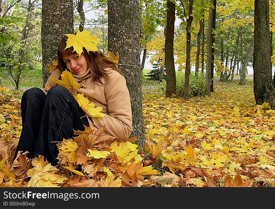 Nice young girl siting in the autumn forest