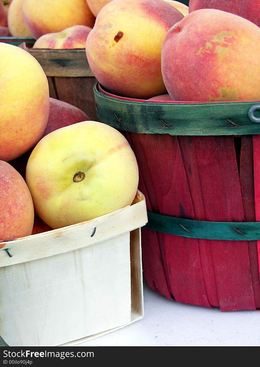 Beautiful ripe peaches in a box and baskets being sold at a roadside market stand. Beautiful ripe peaches in a box and baskets being sold at a roadside market stand