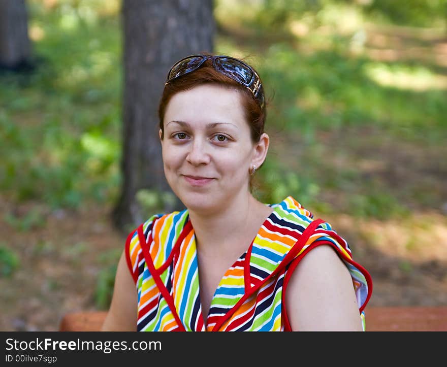 Portrait of the young smiling woman in a wood. Portrait of the young smiling woman in a wood