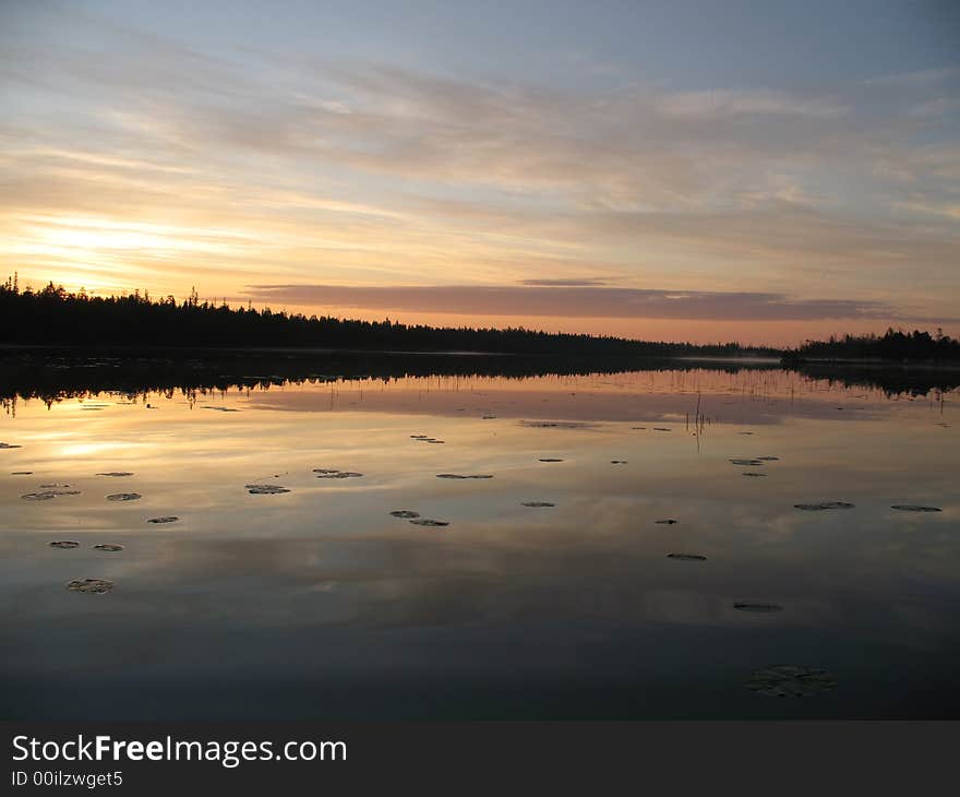 Early morning, fishing. Ideally equal smooth surface of lake, on a surface of water lay water lily's leaves. Early morning, fishing. Ideally equal smooth surface of lake, on a surface of water lay water lily's leaves.