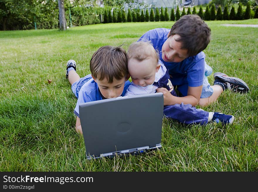 Three cute brothers study on computer