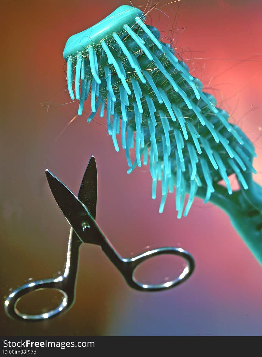 Scissors and hairbrush on a grey background. Scissors and hairbrush on a grey background