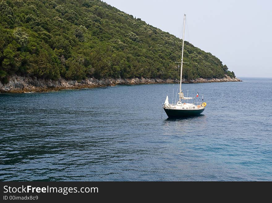 Lonely yacht near olive tree forest coast. Lonely yacht near olive tree forest coast