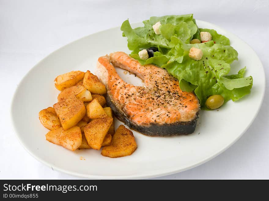 Grilled Salmon with Lettuce Salad and fried Potatoes.