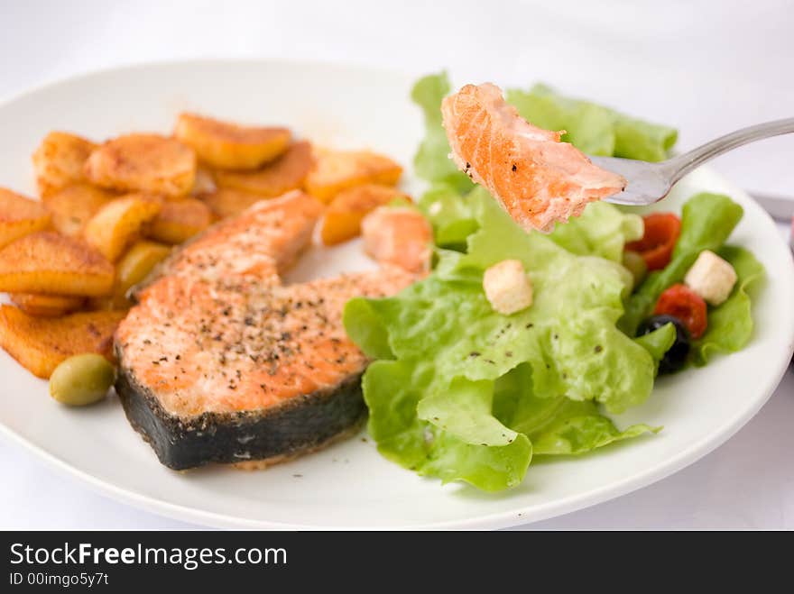 Grilled Salmon with Lettuce Salad and fried Potatoes. Grilled Salmon with Lettuce Salad and fried Potatoes.