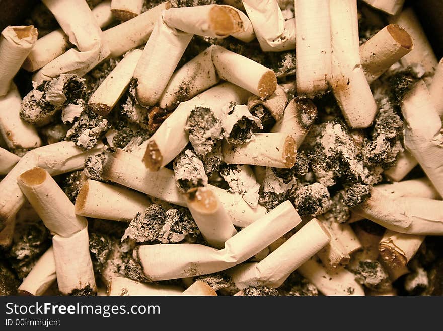 Background of a full ashtray with cigarette butts