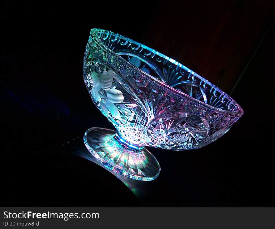 A glass bowl with hints of glowing blue, green, purple and red colours. A glass bowl with hints of glowing blue, green, purple and red colours.