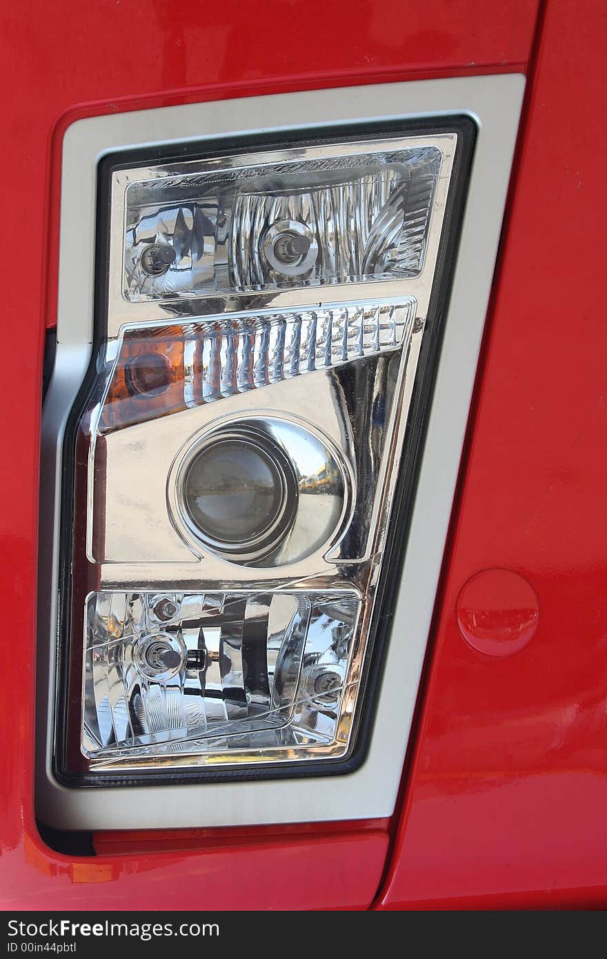 Head-light of red truck with halogen bulbs. Head-light of red truck with halogen bulbs.