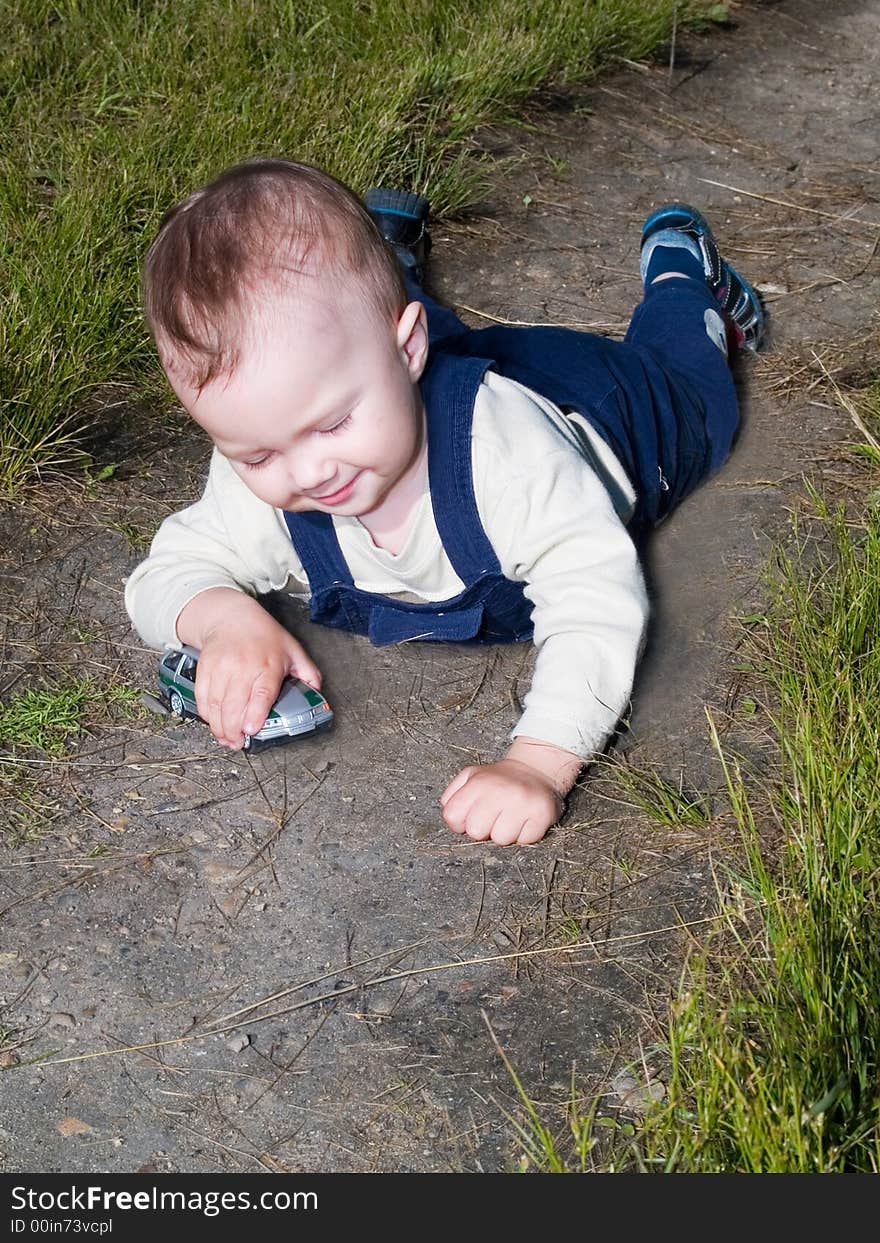 Laying boy playing with car