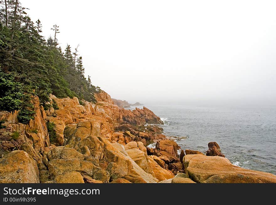 A view of the rocks and rugged coastline of Maine on a foggy morning. A view of the rocks and rugged coastline of Maine on a foggy morning.