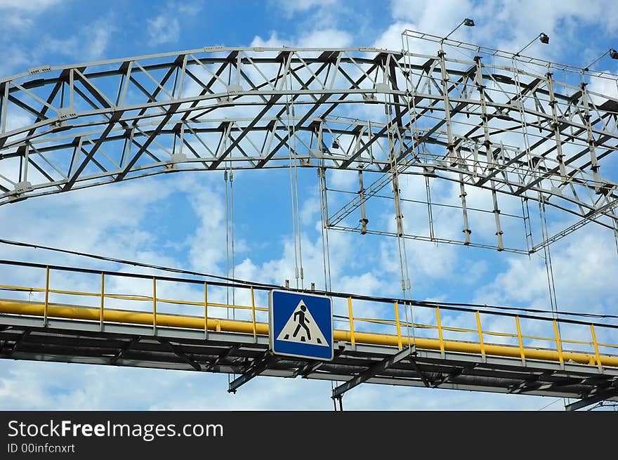 Pedestrian bridge crossing cloudy sky. Pedestrian bridge crossing cloudy sky