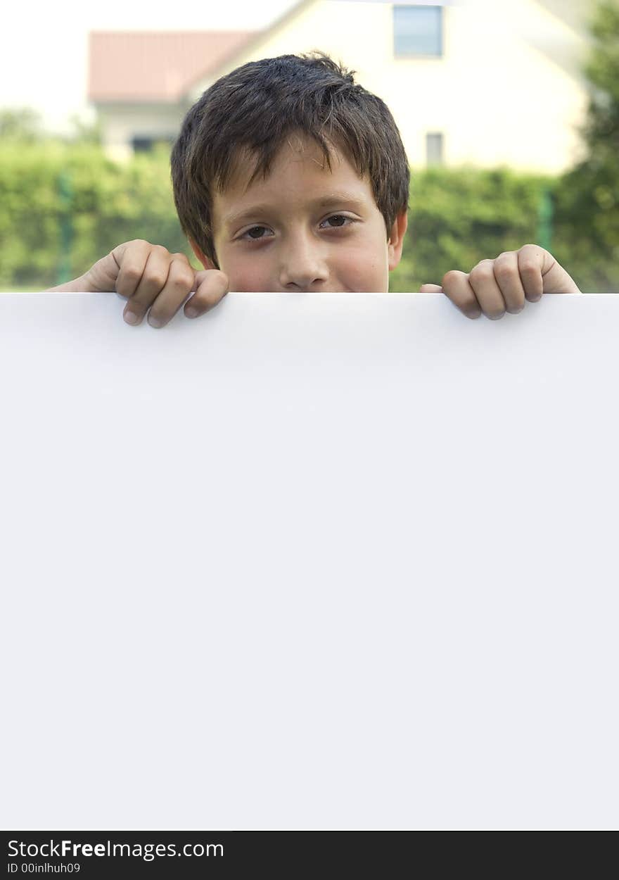 Boy keeps sheet of paper in courtyard of the building