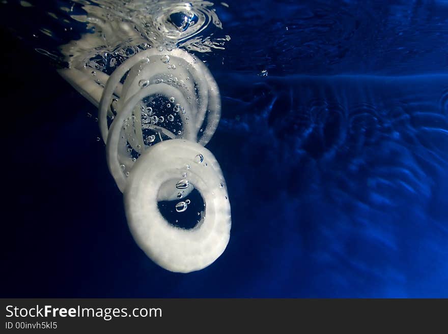 Onion slices sinking in the water. Onion slices sinking in the water