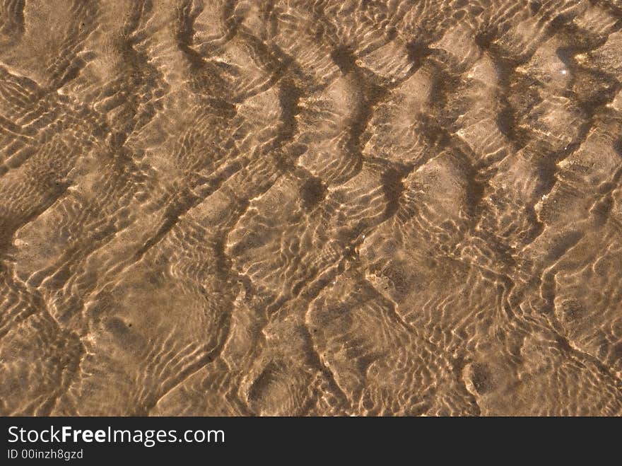 Ripples of light reflecting on river sand. Ripples of light reflecting on river sand