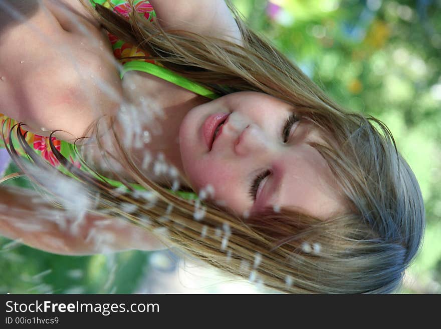 A little girl splashing in the sprinkler. A little girl splashing in the sprinkler