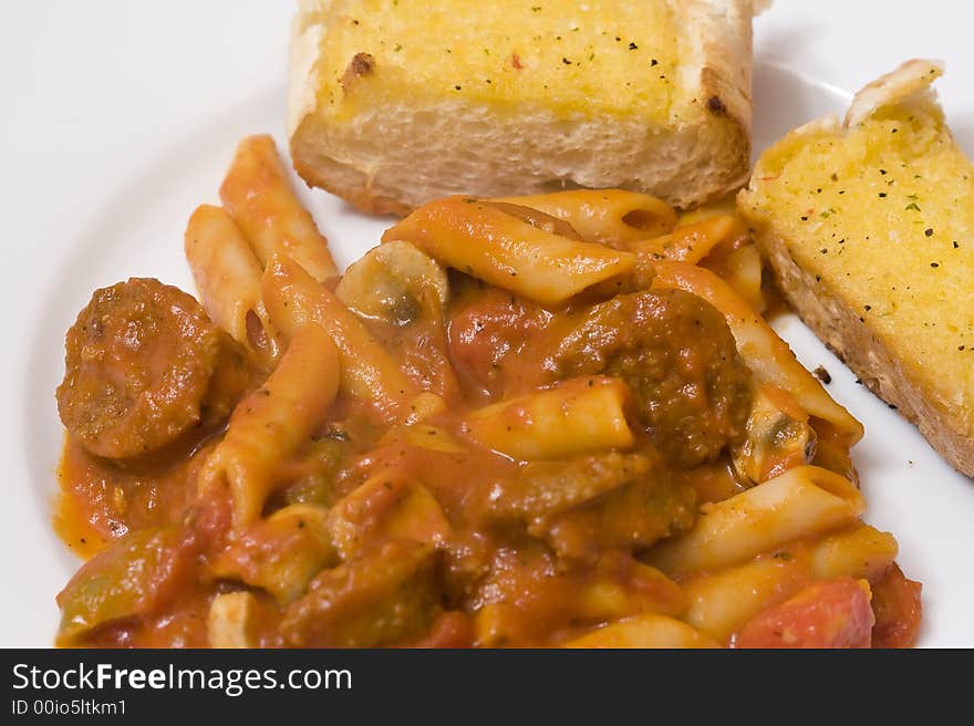 Serving of penne spaghetti white dishes nice reddish colors. Serving of penne spaghetti white dishes nice reddish colors