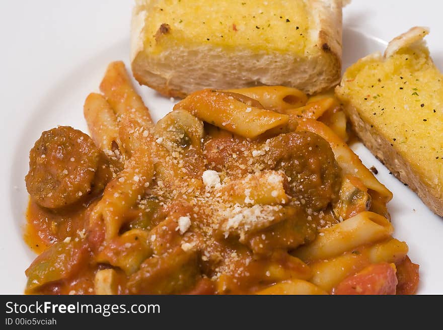 Serving of penne spaghetti white dishes nice reddish colors. Serving of penne spaghetti white dishes nice reddish colors