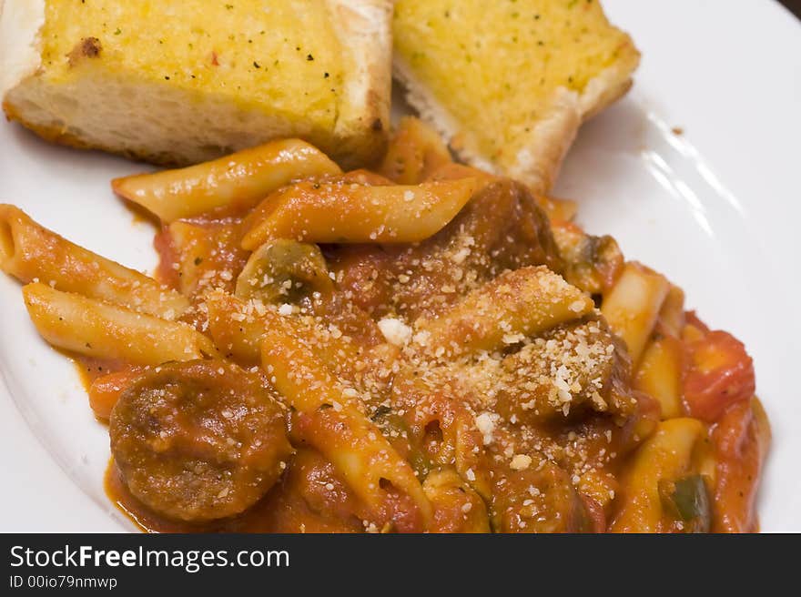 Serving of penne spaghetti white dishes nice reddish colors. Serving of penne spaghetti white dishes nice reddish colors