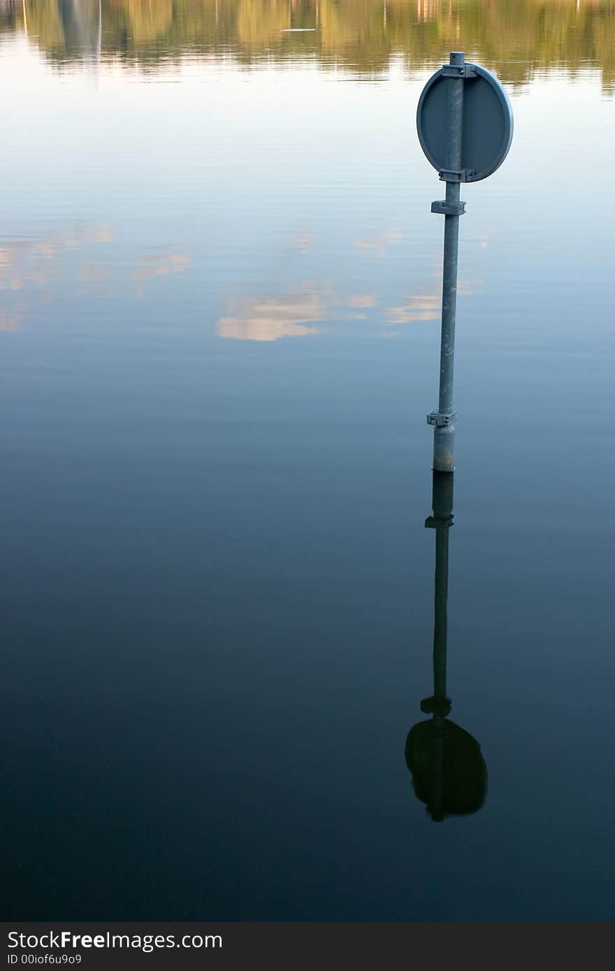 A traffic sign and its reflection in the water. A traffic sign and its reflection in the water