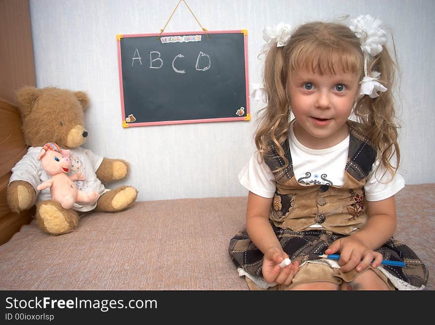 A girl with toys and school alackboard