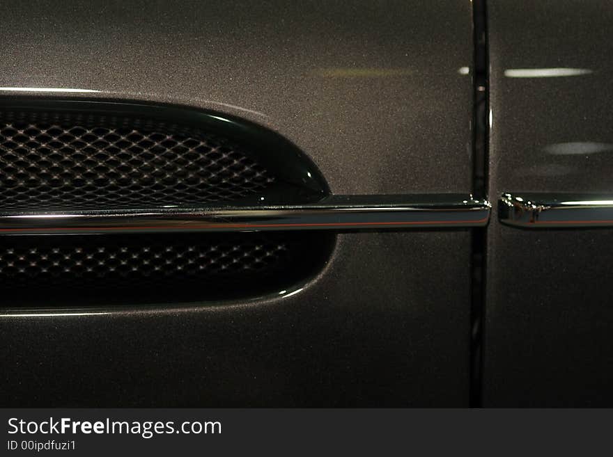 Part of a black and beautiful sportscar. Part of a black and beautiful sportscar