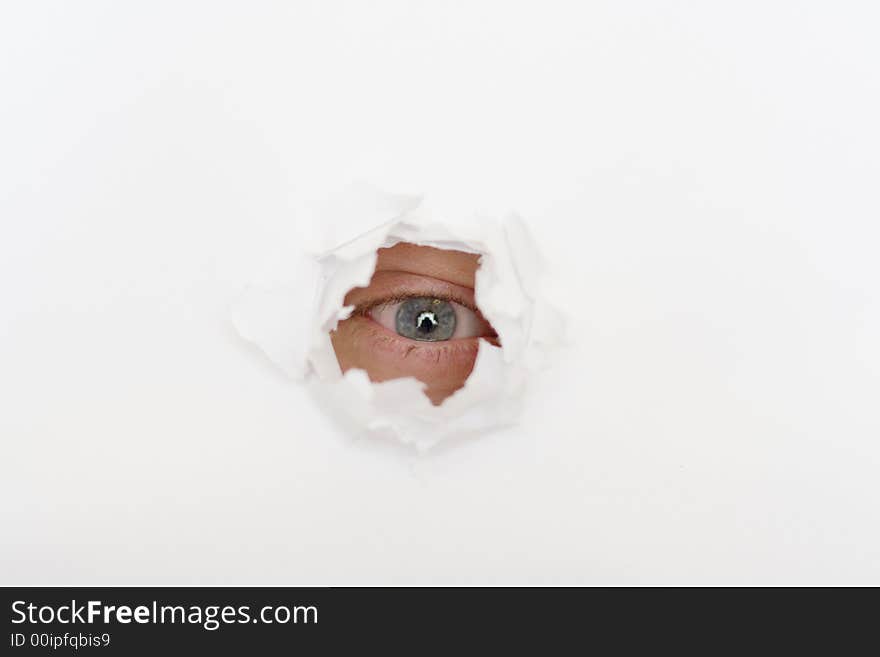 Eye in the hole of white paper