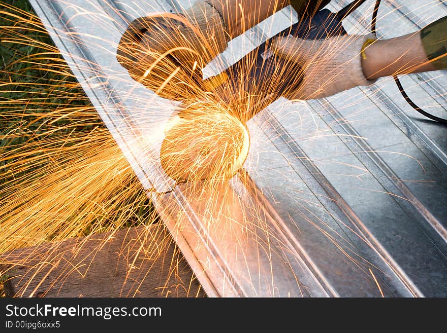 Metal cutting sparks (Man in khaki Working under Metal)