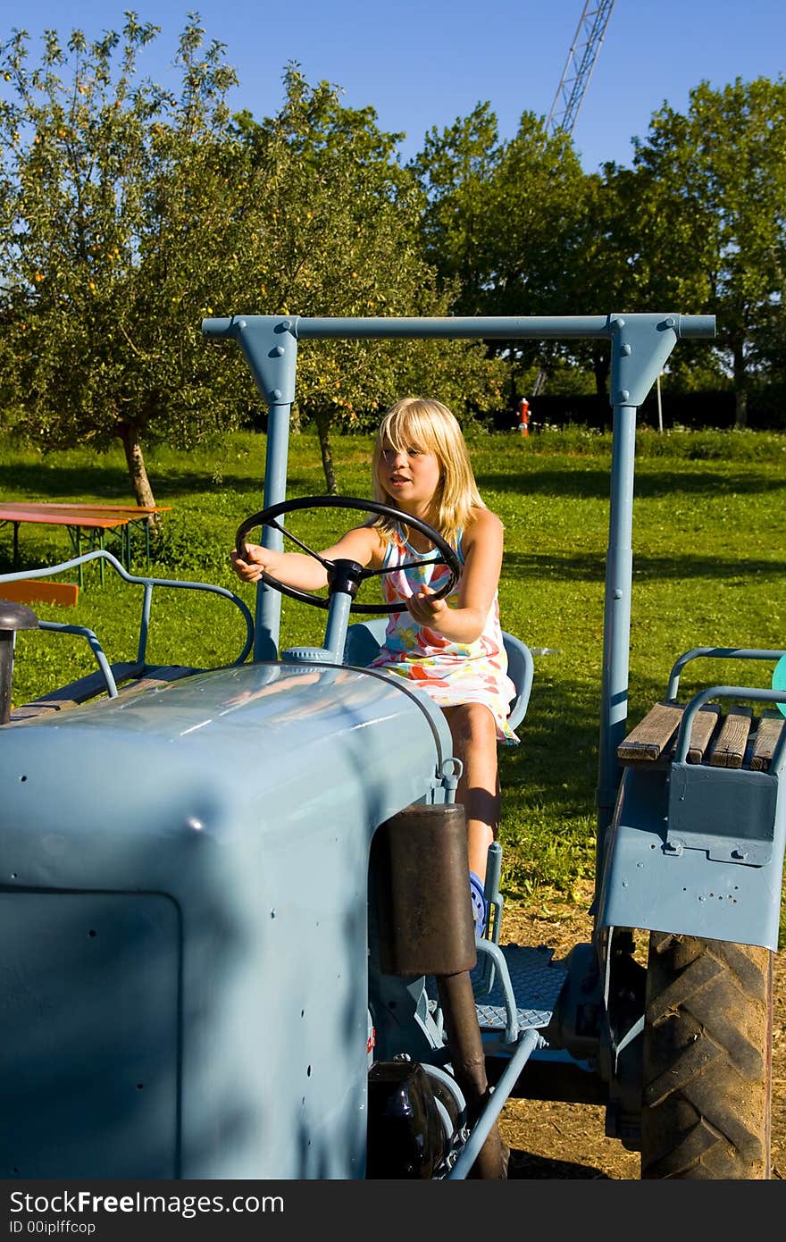 A beautiful farmer's daughter driving a tractor through a green field. A beautiful farmer's daughter driving a tractor through a green field.