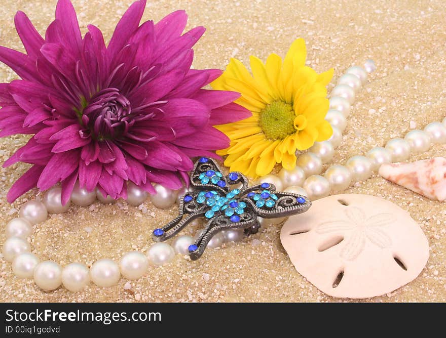 Flowers and Jewelry with Sea Shells on Sand