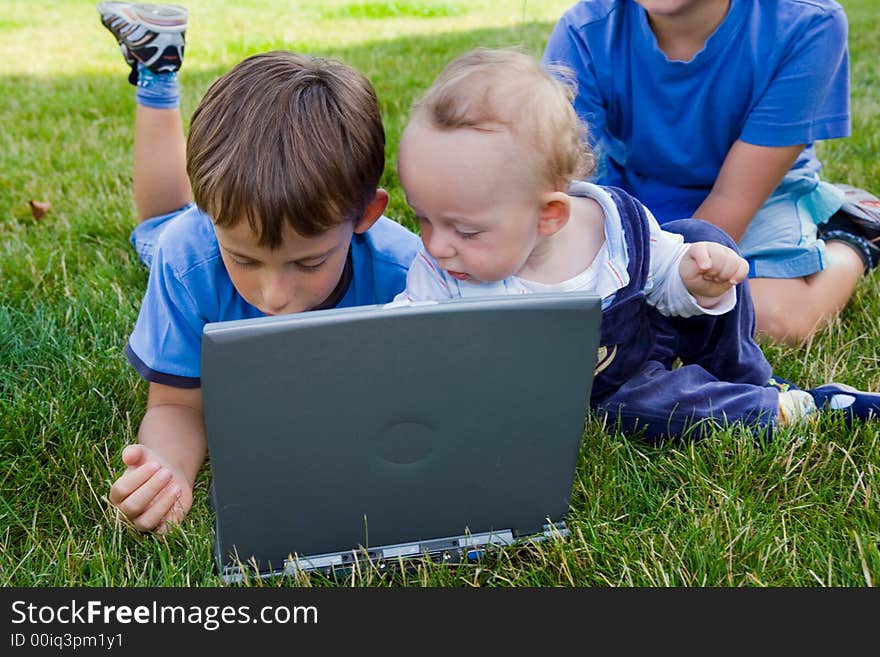 Three cute brothers study on computer