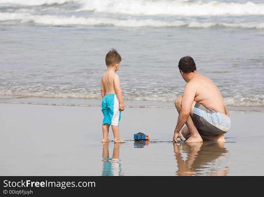 Father and son playing together on the beach