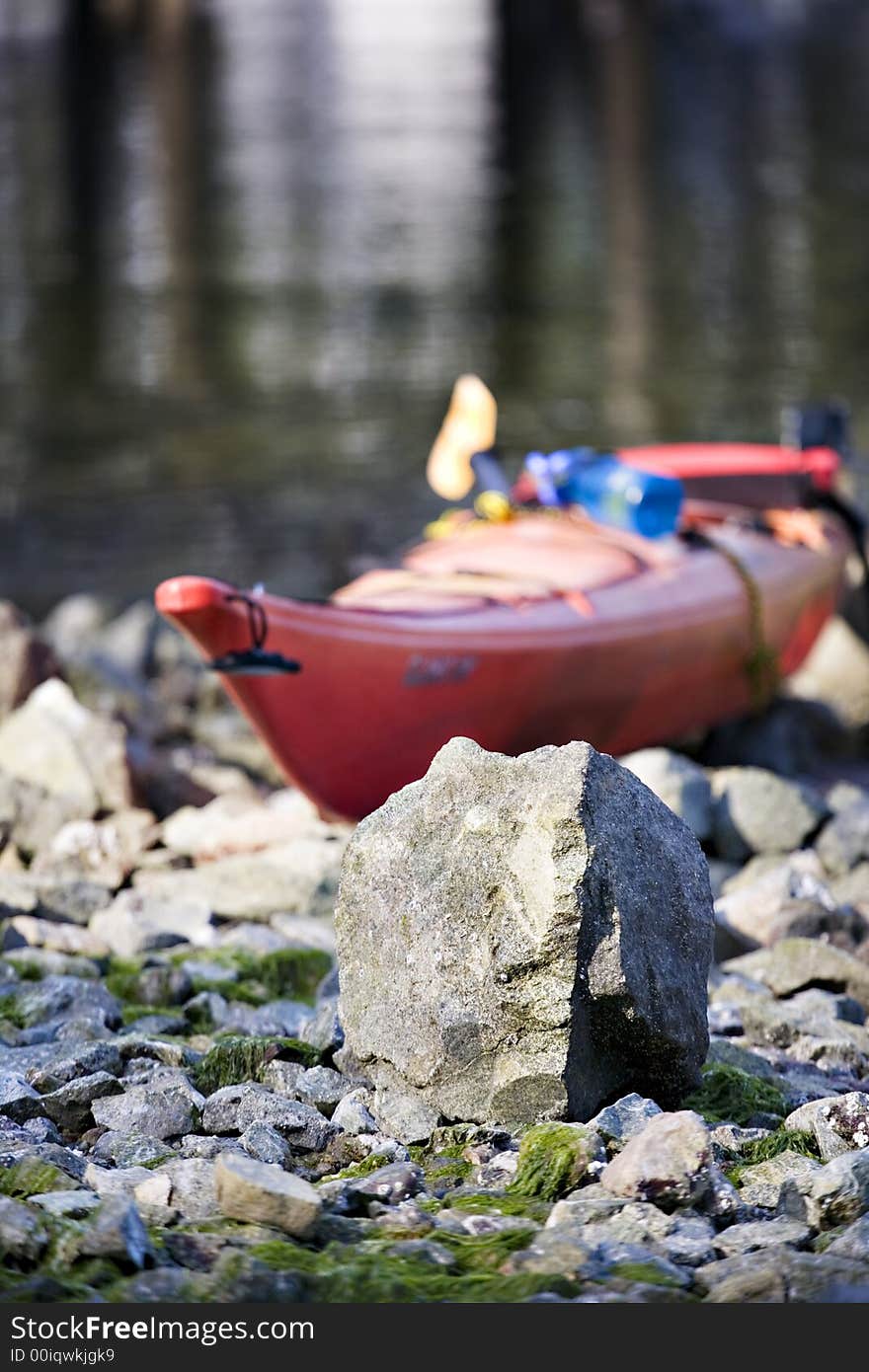 Kayak sitting up on the rocks by shoreline. Kayak sitting up on the rocks by shoreline