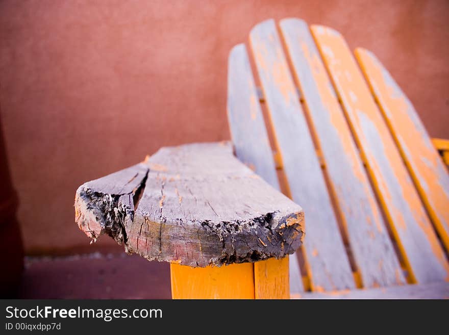 Shallow depth of field with focus on forefront armrest showing detail of broken wood with peeling paint. Shallow depth of field with focus on forefront armrest showing detail of broken wood with peeling paint