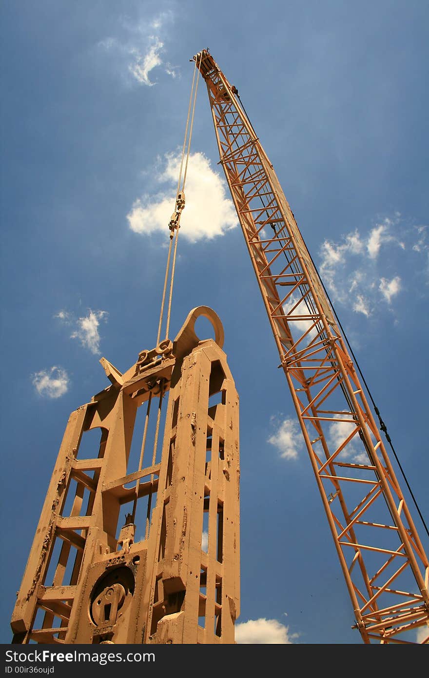 Yellow steel crane drilling foundations for a train station. Yellow steel crane drilling foundations for a train station