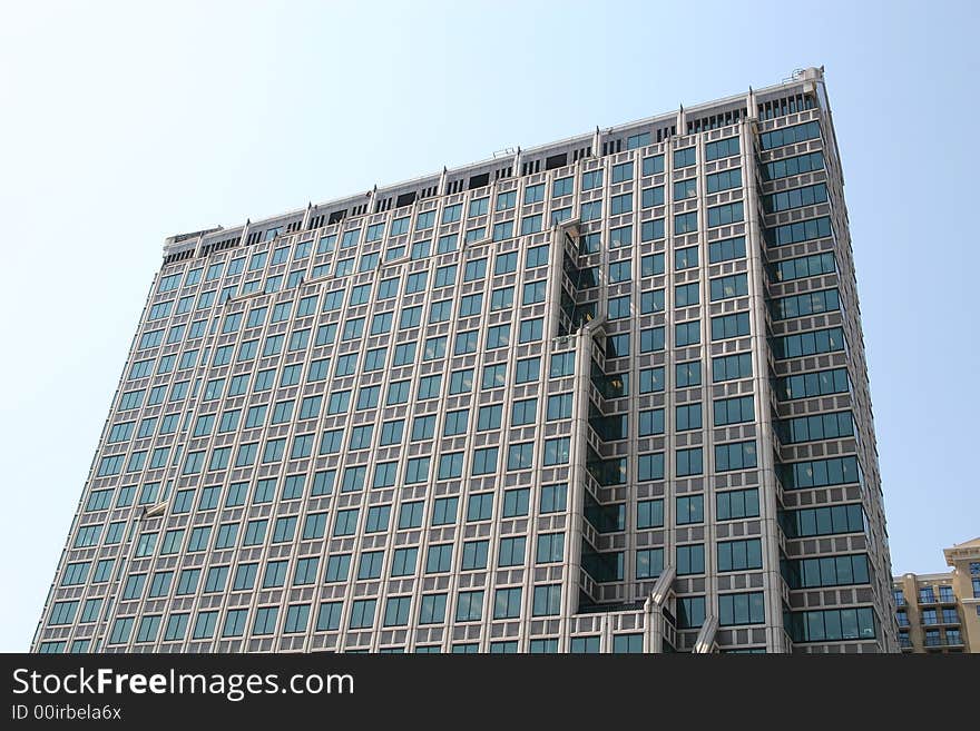 A modern blue glass condo tower in the city. A modern blue glass condo tower in the city