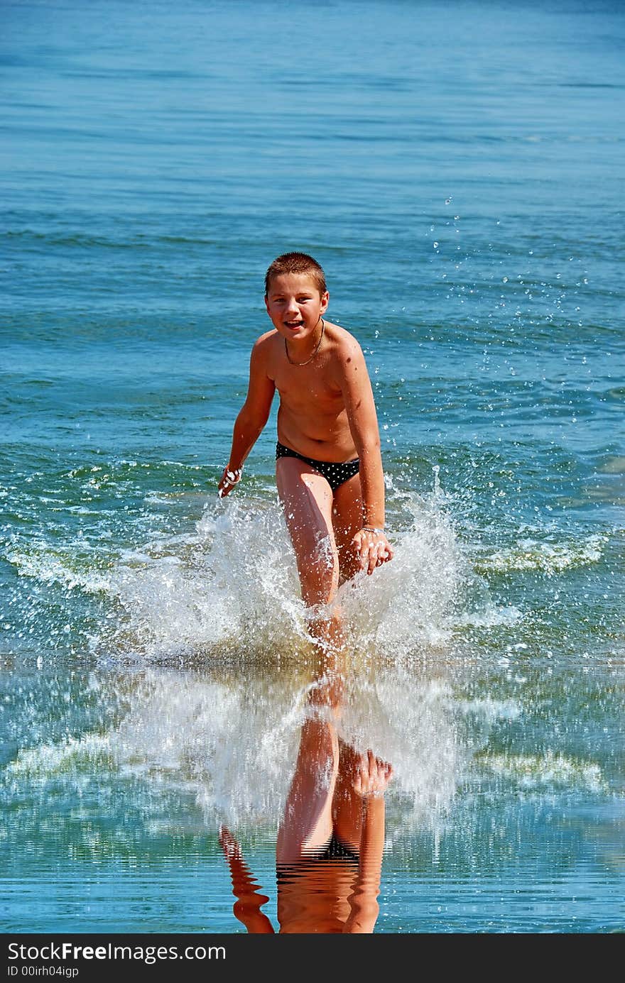 A boy running out of water with a splash. A boy running out of water with a splash
