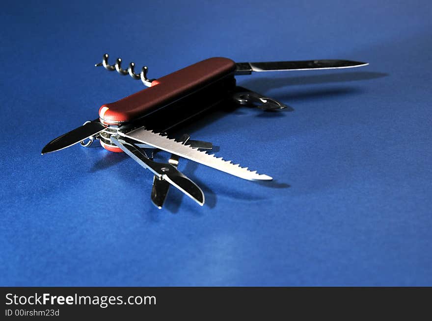 Photo of red penknife on blue background