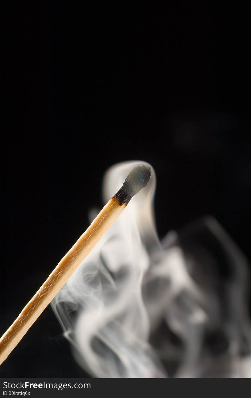 Close up of a smoking match on a black background